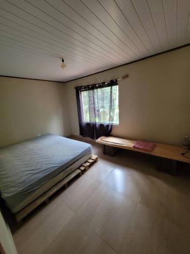 um quarto com uma cama grande e uma janela em Descanso imerso à natureza! em Nova Friburgo
