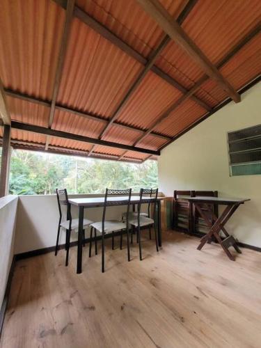 ein Esszimmer mit einem Tisch und Stühlen in einem Zimmer in der Unterkunft Descanso imerso à natureza! in Nova Friburgo