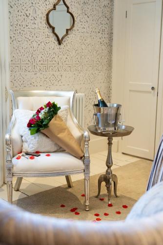 a white chair with a bouquet of flowers and a bottle of champagne at Gileston Manor Luxury B&B in Barry