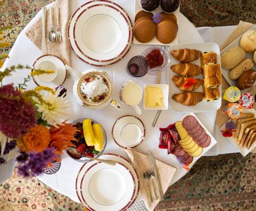 a table topped with plates of food and desserts at Gileston Manor Luxury B&B in Barry