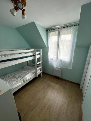 une petite chambre avec deux lits superposés et une fenêtre dans l'établissement Maison à 3 min de Cabourg / 5min à pieds de la mer, à Dives-sur-Mer