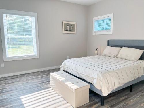 a white bedroom with a large bed and two windows at New Build Private Home 3br2ba - Pet Friendly in South Euclid
