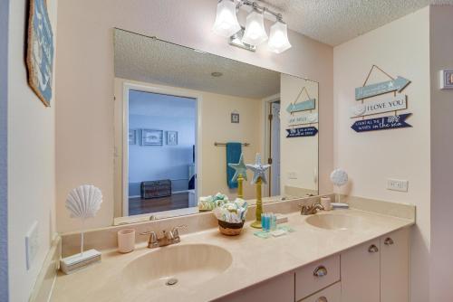 a bathroom with two sinks and a large mirror at Clearwater Beachfront Condo with Heated Pool Access! in Clearwater Beach