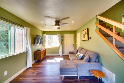 a living room with a couch and a staircase at Running Springs Cabin with Spacious Deck and Hot Tub! in Running Springs