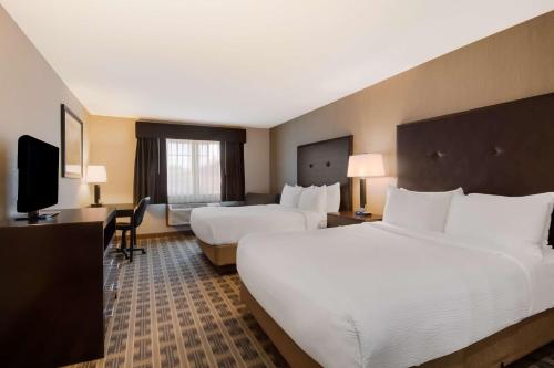 ein Hotelzimmer mit 2 Betten und einem TV in der Unterkunft Best Western University Inn and Suites in Forest Grove