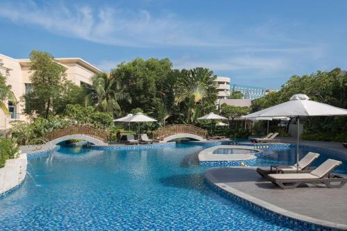 una piscina con sillas y sombrillas en un hotel en Radisson Blu Cebu, en Cebú