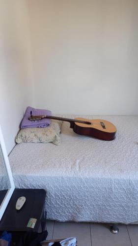 a guitar sitting on top of a bed at Apartamento no condomínio Bilbao - B7 202 in Teresina