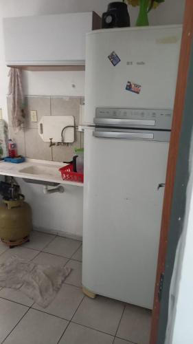 una cocina con una nevera blanca con imanes. en Apartamento no condomínio Bilbao - B7 202, en Teresina