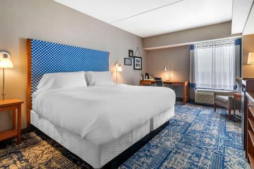 a hotel room with a large bed and a desk at Bangor Aviator Hotel BW Premier Collection in Bangor
