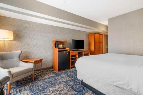 a hotel room with a bed and a chair and a television at Bangor Aviator Hotel BW Premier Collection in Bangor