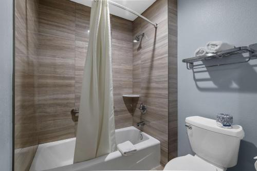 a bathroom with a white toilet and a shower at Suites Escondido CA in Escondido