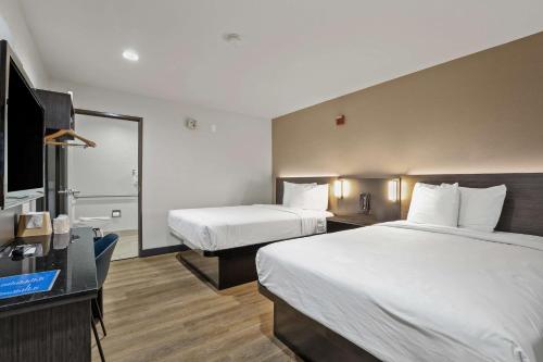 a hotel room with two beds and a flat screen tv at Suites Escondido CA in Escondido