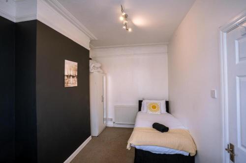 een slaapkamer met een bed met een kussen erop bij Cozy 4-Bedroom in Coventry: Your Home Away From Home in Coventry