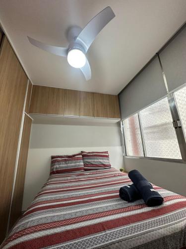 a bedroom with a bed with a ceiling fan at A tranquilidade está a seu alcance. in São Vicente