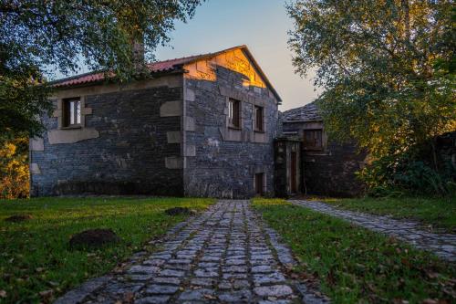 an old stone house with a cobblestone road in front of it at Casa dos do Carvalho - Miradouro da Branda in Branda de Santo António