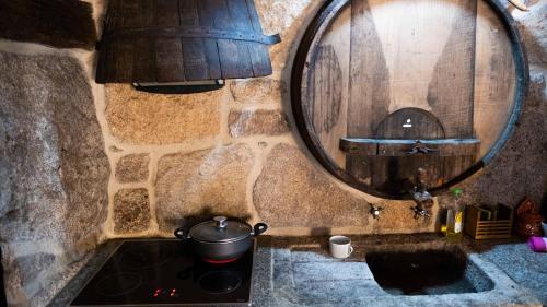 una cocina con una olla en una estufa y un barril en Casa dos do Carvalho - Miradouro da Branda, en Branda de Santo António