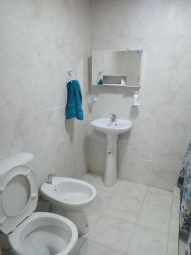 a white bathroom with a toilet and a sink at Finca Doña Antonia in Pueblo Moreno