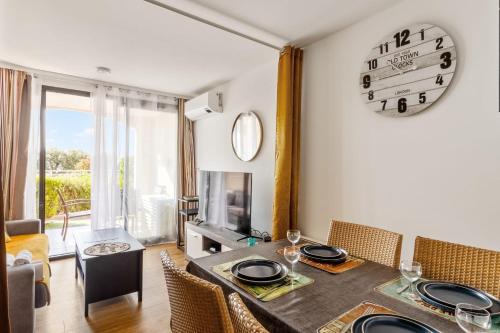 une salle à manger avec une table et une horloge au mur dans l'établissement Appartement Wemyssia - Welkeys, à Cannes
