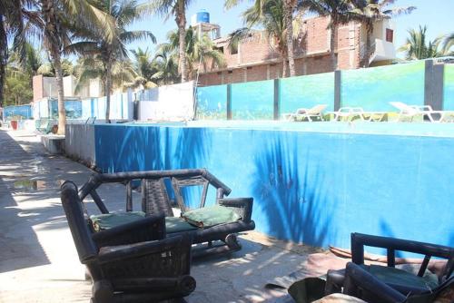duas cadeiras sentadas ao lado de uma piscina em Ángeles del Mar em Piura