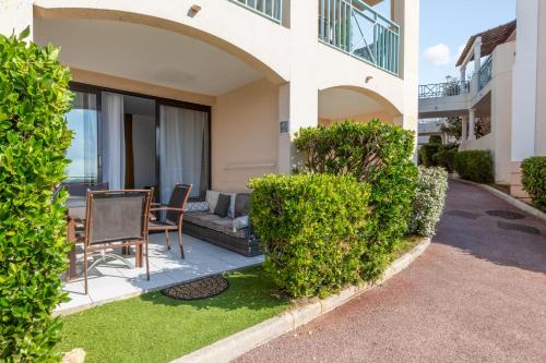 une maison avec une table et des chaises dans une cour dans l'établissement Appartement Wemyssia - Welkeys, à Cannes