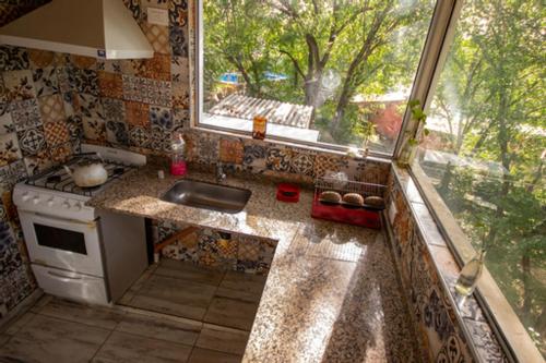 una pequeña cocina con fregadero y ventana en El descanso en Villa Carlos Paz