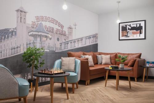 a living room with a couch and a table with chessitures at Staybridge Suites Brighton by IHG in Brighton & Hove