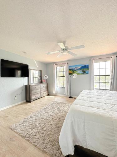 a bedroom with a bed and a ceiling fan at Luxry villa 6 miles from Disney in Orlando