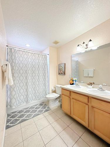 a bathroom with a sink and a toilet and a shower at Luxry villa 6 miles from Disney in Orlando