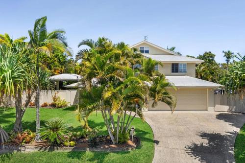 a house with palm trees in front of a driveway at 11 Dalmor Court in Coolum Beach
