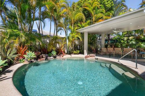 a swimming pool in a yard with palm trees at 11 Dalmor Court in Coolum Beach