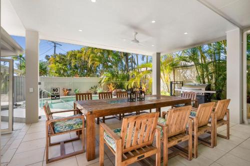 a dining room with a large wooden table and chairs at 11 Dalmor Court in Coolum Beach