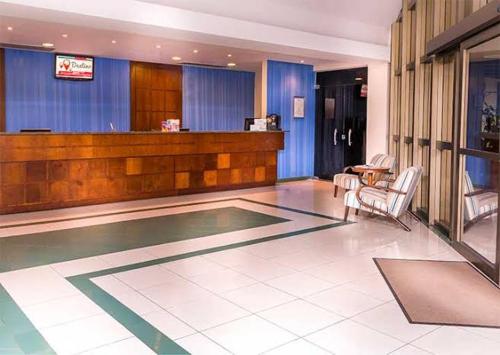 a lobby with chairs and a bar in a building at Flat em Franca SP in Franca