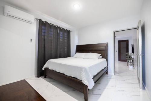1 dormitorio con 1 cama con cabecero de madera y espejo en Lux Ramey Cir D 2 king bed w/Wi-Fi near airport., en Aguadilla
