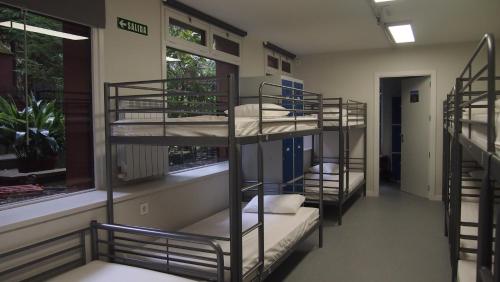 a room with three bunk beds and a window at Albergue Plaza Catedral in Pamplona