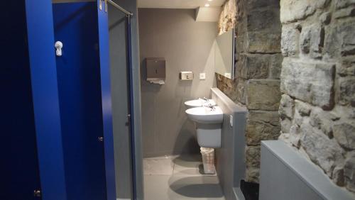 a bathroom with a toilet, sink, and mirror at Albergue Plaza Catedral in Pamplona
