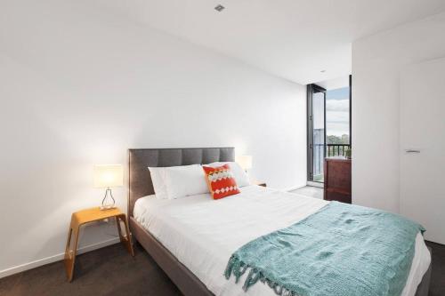 a bedroom with a bed and a large window at Urban Oasis in the Heart of Richmond Cultural Hub in Melbourne