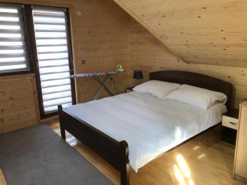 a bedroom with a bed in a wooden cabin at Ski Chalet Jahorina in Jahorina