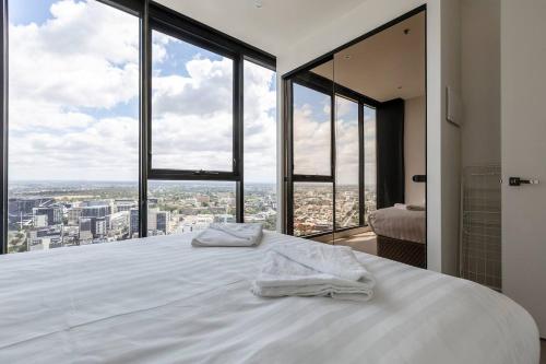 um quarto com uma grande cama branca e janelas grandes em Light, Elevated Living near Queen Victoria Market em Melbourne
