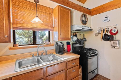 a kitchen with a sink and a stove at Treehouse On Rainbow - A newly remodeled cabin perfect for a mountain getaway in Big Bear City