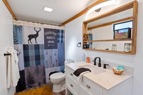a bathroom with a deer shower curtain and a sink at Treehouse On Rainbow - A newly remodeled cabin perfect for a mountain getaway in Big Bear City