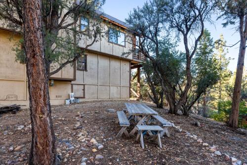 a picnic table and two chairs in front of a building at Treehouse On Rainbow - A newly remodeled cabin perfect for a mountain getaway in Big Bear City