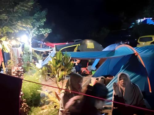 grupa ludzi siedzących w namiocie w nocy w obiekcie Tapian Ratu Camp w mieście Bukittinggi
