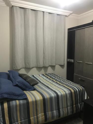 1 dormitorio con 1 cama, vestidor y ventana en Quarto para Casal Blumenau en Blumenau