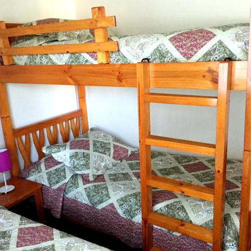 a bedroom with two bunk beds and a ladder at Cabañas CentroMontt in Puerto Montt