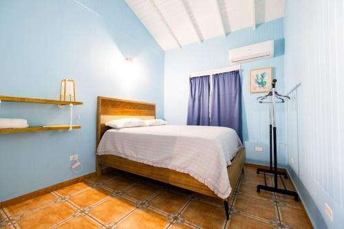een slaapkamer met een bed in een blauwe kamer bij Jobos Beach Apt #1 near food truck and beach . in Isabela