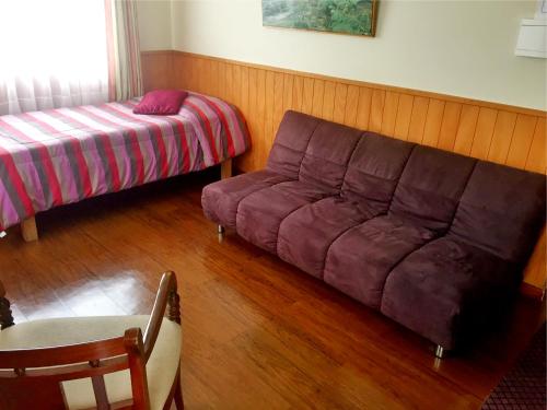 sala de estar con sofá y cama en Cabañas CentroMontt, en Puerto Montt