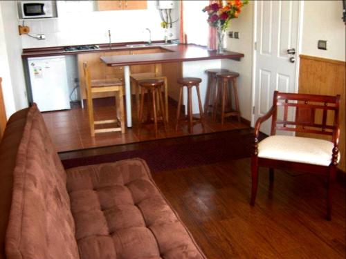sala de estar con sofá y cocina en Cabañas CentroMontt, en Puerto Montt