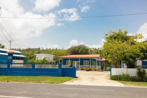 a blue fence in front of a house at Jobos Beach Apt #1 near food truck and beach . in Isabela