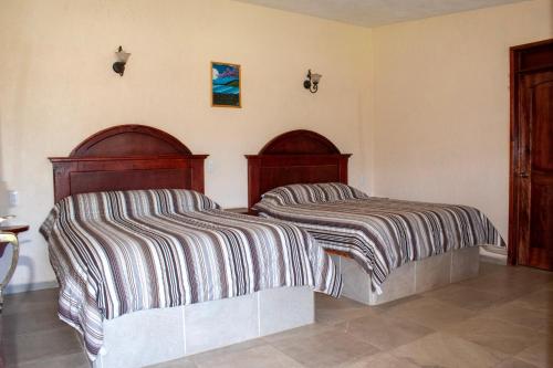 two beds sitting next to each other in a bedroom at Finca Marix in Villa del Carbón