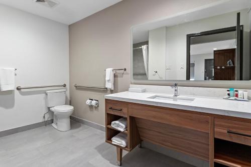 a bathroom with a sink and a toilet and a mirror at Hawthorn Extended Stay by Wyndham Port Arthur in Port Arthur